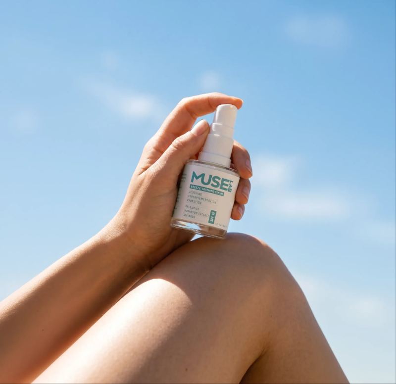 Muse Lab — hand holding serum against sky